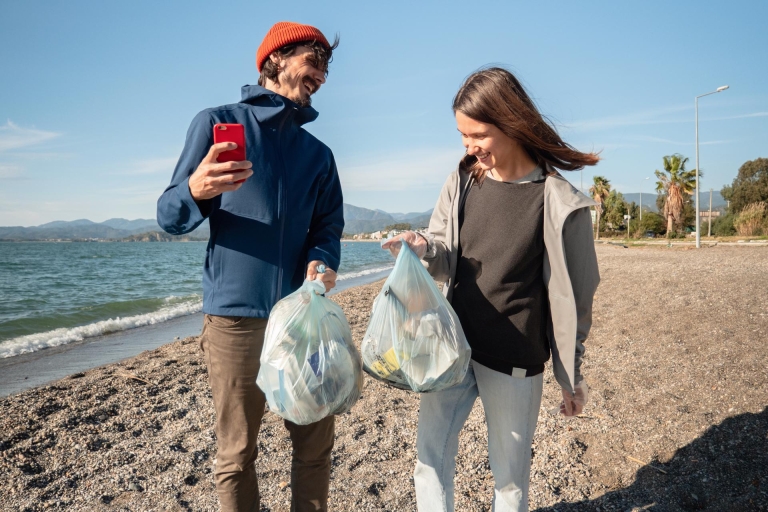 Community business young woman and man cleaning the beach