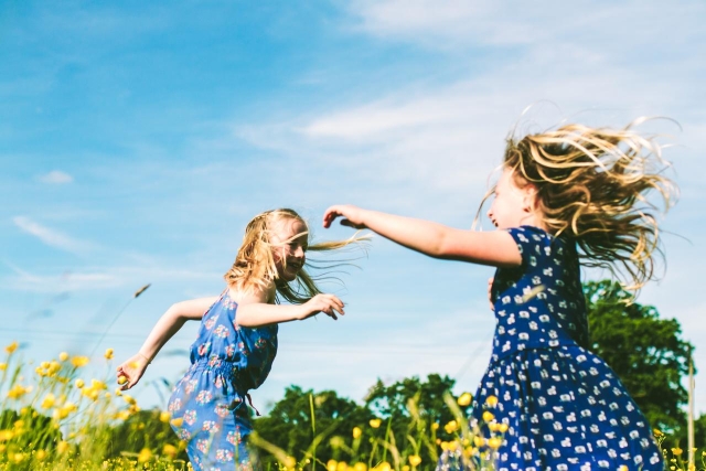 Two girls dancing in a meadow