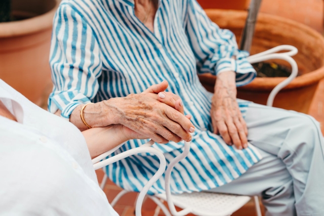Hands of a senior daughter and mother