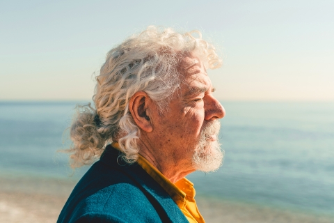 Senior man taking the view on the beach